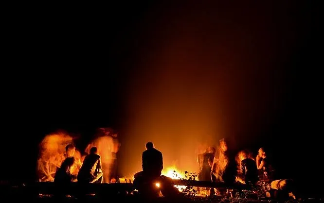 People gathered around a fireside at night